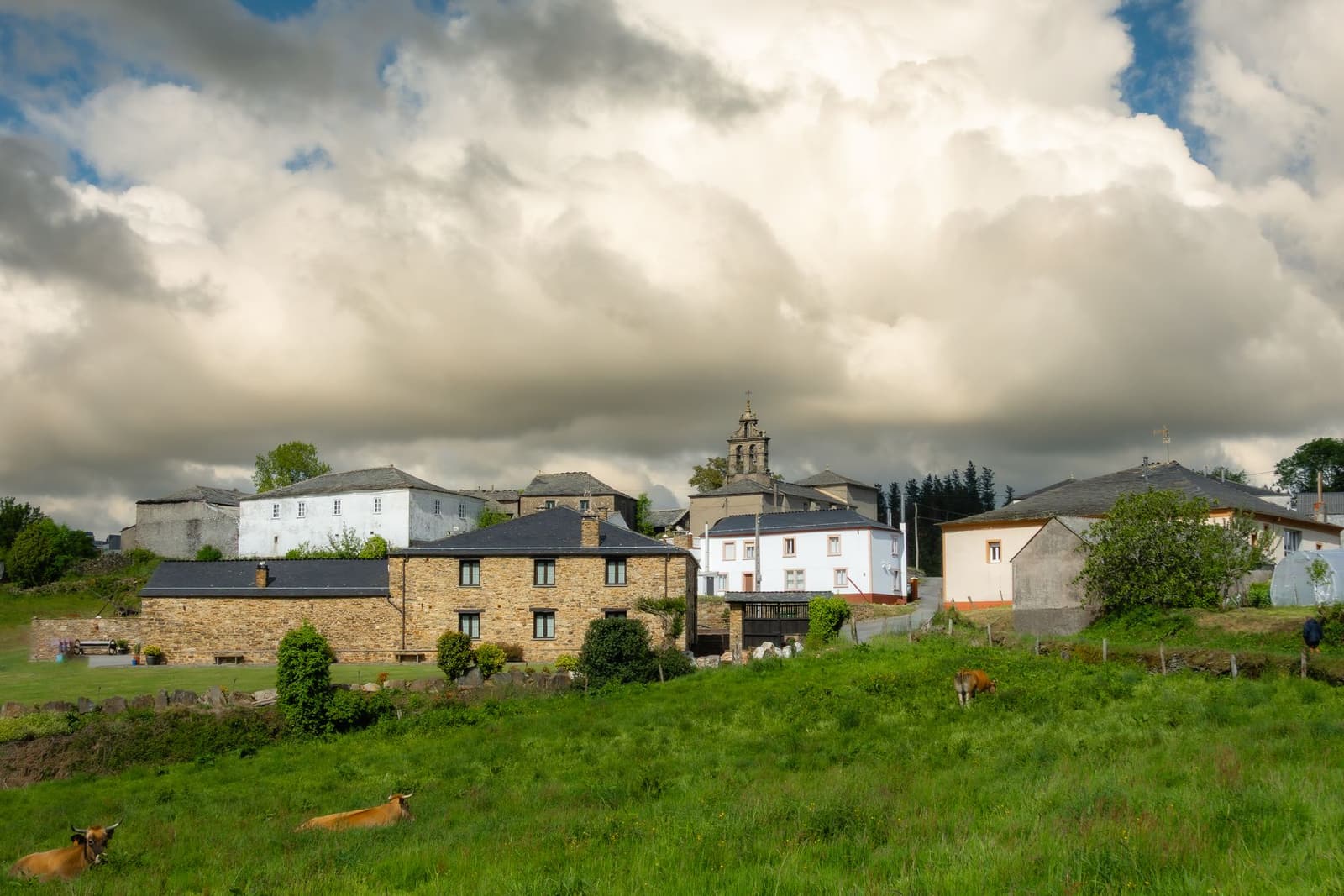 Aldea con casas de piedra y prados verdes